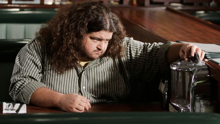 Large man sitting at a booth in a diner